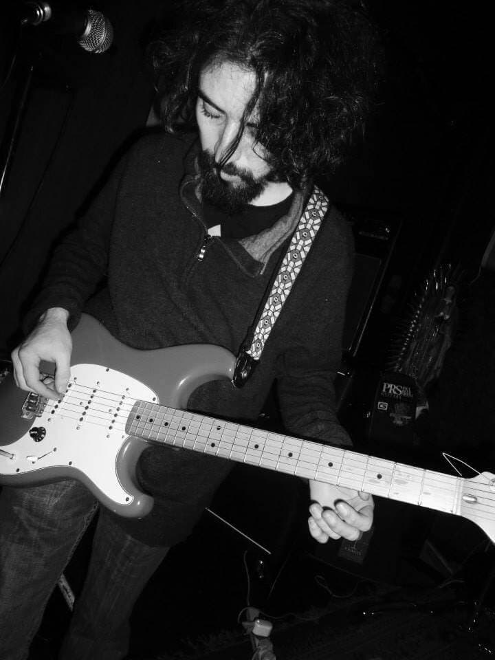 Brendan playing guitar live on stage.